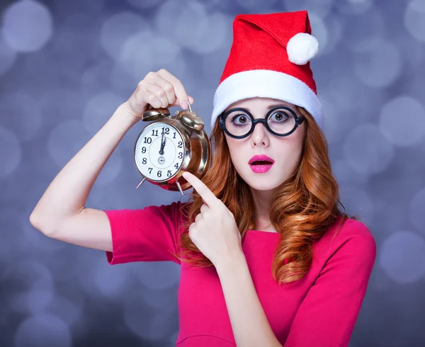 Pelirroja en sombrero de Navidad con reloj —  Fotos de Stock