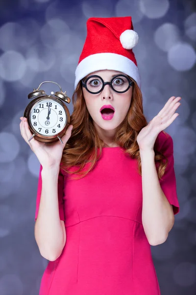 Ragazza rossa in cappello di Natale con orologio — Foto Stock