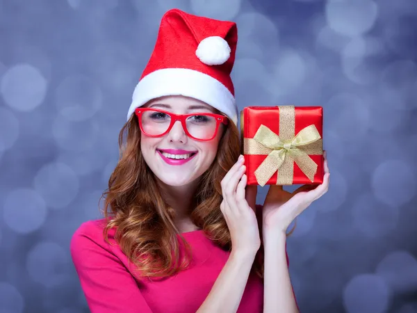 Redhead girl in christmas hat with gift. — Stock Photo, Image