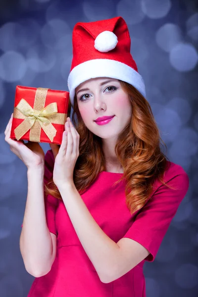 Redhead girl in christmas hat with gift. — Stock Photo, Image