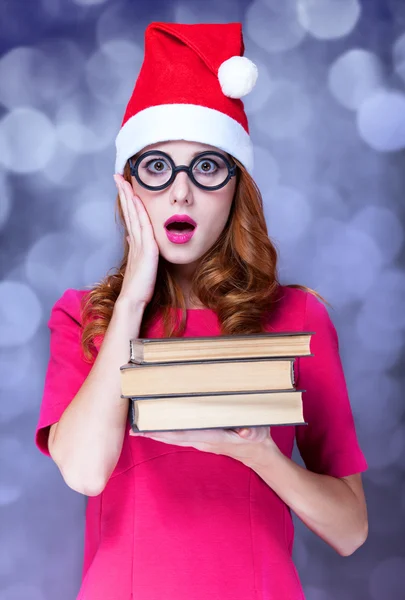Pelirroja en sombrero de Navidad con libros —  Fotos de Stock