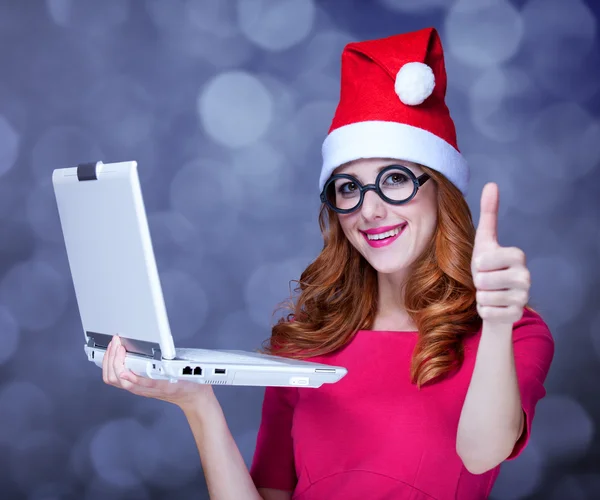 Ragazza rossa in cappello di Natale con computer portatile — Foto Stock