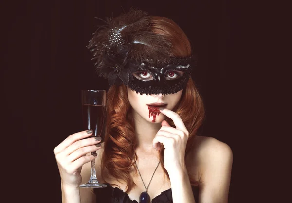 Redhead vampier vrouw in masker met glas van bloed. — Stockfoto