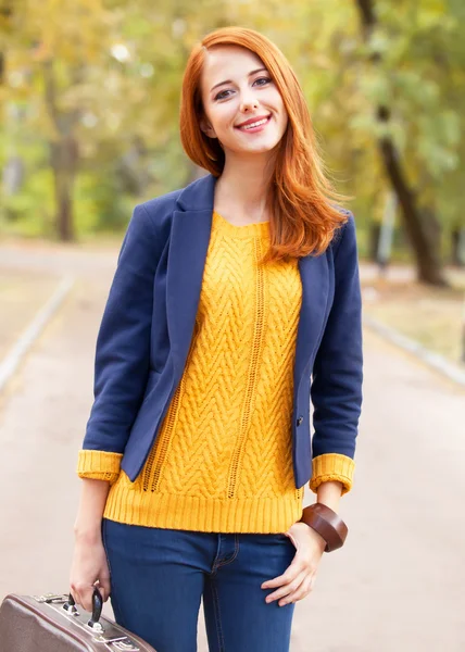 Girl with suitcase at autumn outdoor — Stok fotoğraf