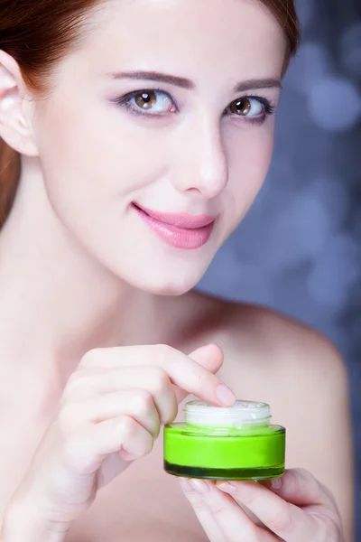 Beauty face of young redhead women with cosmetic cream on a chee — Stock Photo, Image