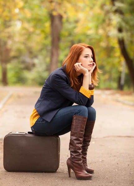 Girl with suitcase at autumn outdoor — Stockfoto