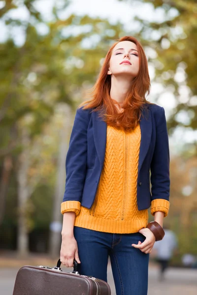 Mädchen mit Koffer im Herbst im Freien — Stockfoto