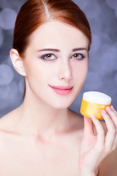 Beauty face of young redhead women with cosmetic cream on a chee — Stock Photo, Image