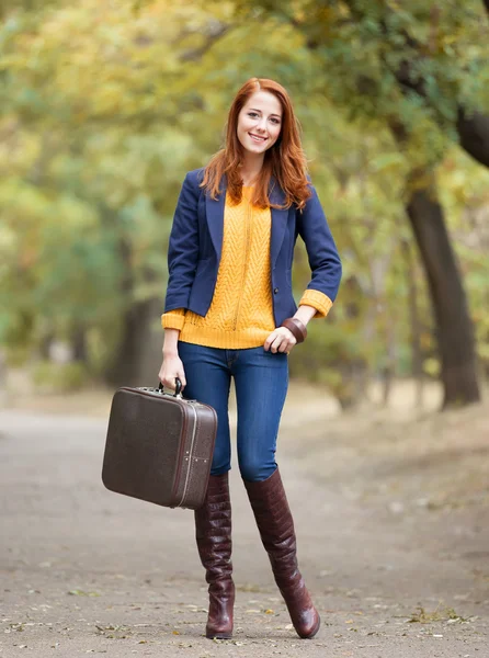 Girl with suitcase at autumn outdoor — Stok fotoğraf