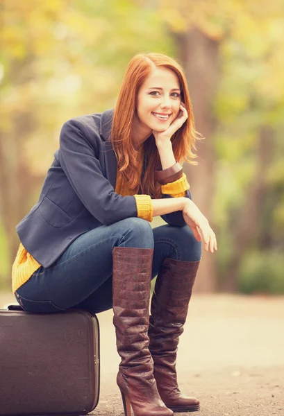 Girl with suitcase at autumn outdoor — Stok fotoğraf