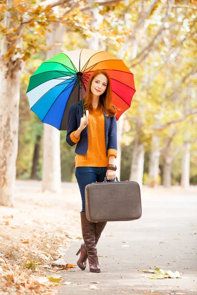 Menina com mala e guarda-chuva no outono ao ar livre — Fotografia de Stock