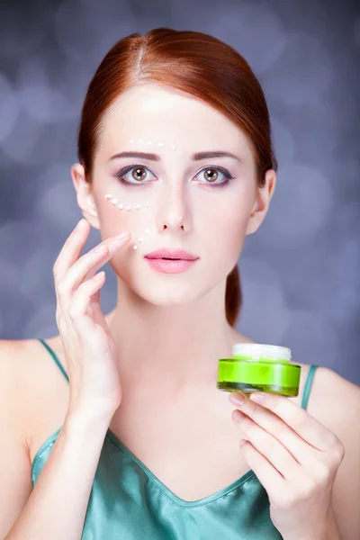 Beauty face of young redhead women with cosmetic cream on a chee — Stock Photo, Image