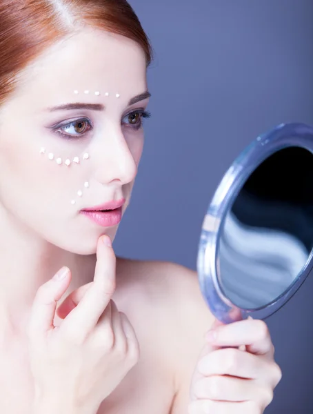 Beauty face of young redhead women with cosmetic cream on a chee — Stock Photo, Image