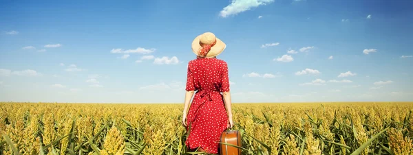Redhead girl with suitcase at corn field. — Stock Photo, Image