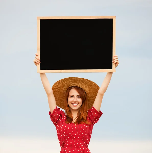 Fille rousse avec tableau noir au champ de blé — Photo