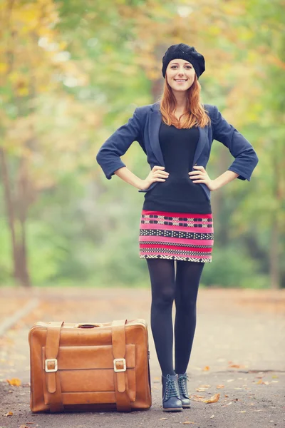 Rothaarige Mädchen mit Koffer im Herbst im Freien. — Stockfoto