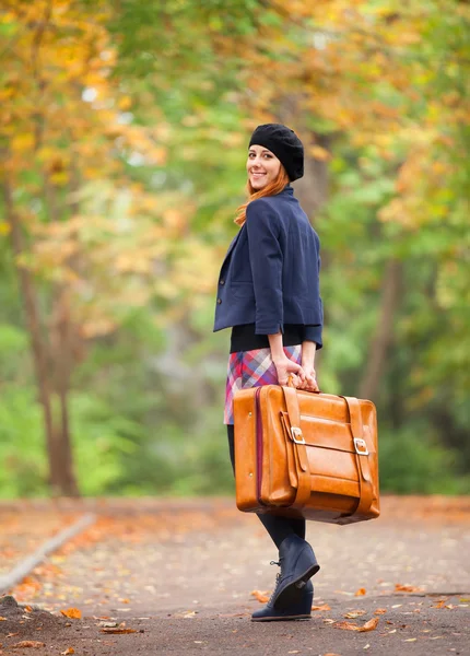 Rothaarige Mädchen mit Koffer im Herbst im Freien. — Stockfoto