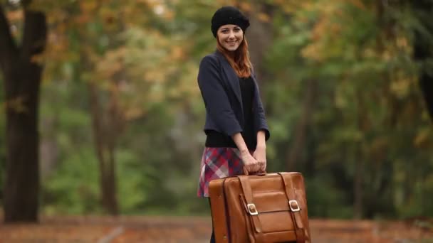 Rusovláska dívka s kufrem na venkovní — Stock video