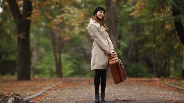 Roodharige meisje met koffer in buiten — Stockvideo