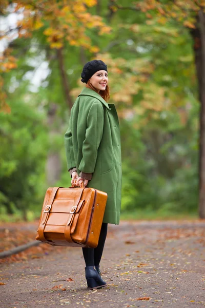 Pelirroja con maleta en otoño al aire libre . — Foto de Stock