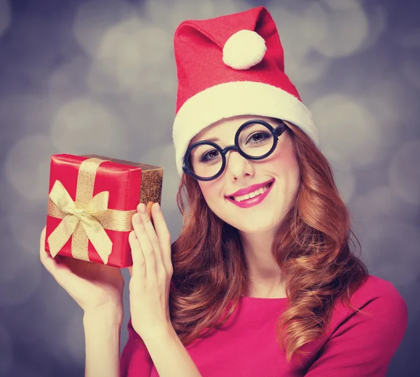 Pelirroja en sombrero de Navidad con regalo . —  Fotos de Stock