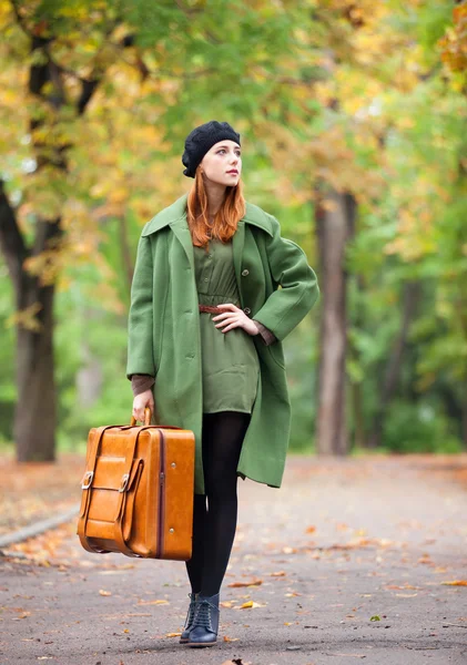 Pelirroja con maleta en otoño al aire libre . — Foto de Stock