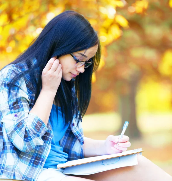 Adolescente avec ordinateur portable dans le parc . — Photo