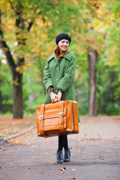 Redhead girl with suitcase at autumn outdoor. — Stock Photo, Image