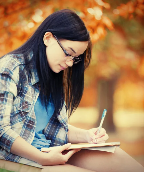 Teen flicka med anteckningsboken i parken. — Stockfoto