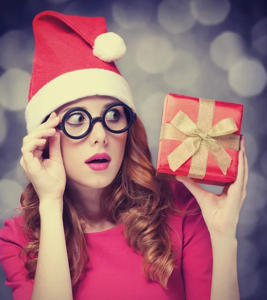 Rödhårig tjej i jul hatt med gåva. — Stockfoto