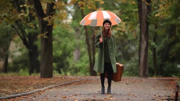 Pelirroja con maleta en otoño al aire libre . — Vídeos de Stock