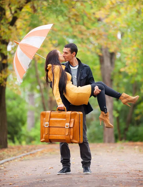 Couplewith umbrella kissing outdoor in the park — Stock Photo, Image