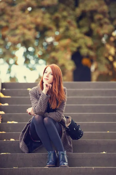 Pelirroja chica con sentado al aire libre . — Foto de Stock