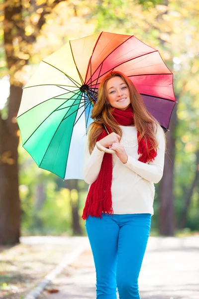 Teen girl in red scarf with umbrella at autumn outdoor — Stock Photo, Image