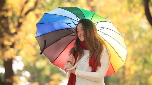 Menina adolescente em cachecol vermelho com guarda-chuva no outono ao ar livre — Vídeo de Stock