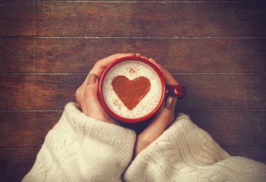 Kalp şekli ile kahve fincan sıcak tutan kadın