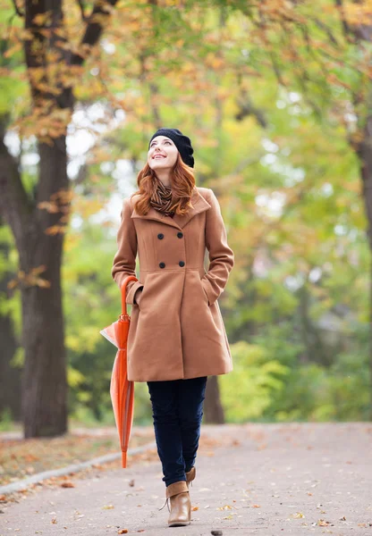 Redhead girl with umbrella at autumn outdoor — Stock Photo, Image