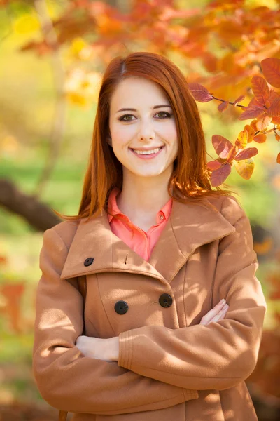 Redhead girl in autumn park — Stock Photo, Image
