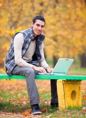 sonbahar parkta oturan defter ile programcı