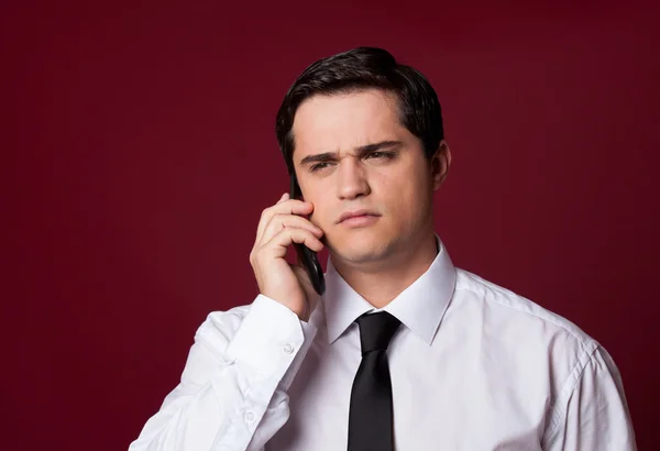 Homem com celular no fundo vermelho — Fotografia de Stock