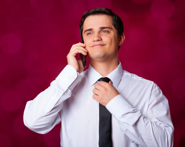 Homem com celular no fundo vermelho — Fotografia de Stock