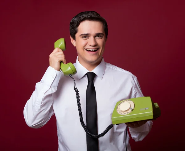 Homme avec téléphone rétro sur fond rouge — Photo