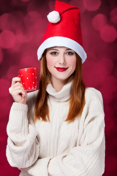Menina ruiva no chapéu de Natal com copo — Fotografia de Stock