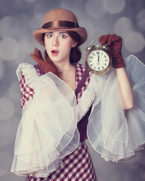 Beautiful redhead women with clock. — Stock Photo, Image