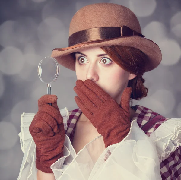 Beautiful redhead women with magnifying glass. — Stock Photo, Image