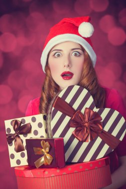 Kızıl saçlı kız hediyeler kırmızı arka plan ile
