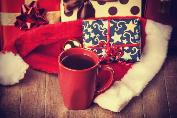 Filiżankę kawy i prezenty w tle — Zdjęcie stockowe