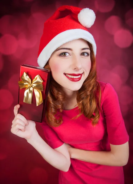 Pelirroja chica con regalos sobre fondo rojo —  Fotos de Stock