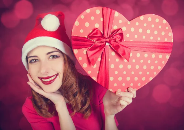 Redhead girl with gifts on red background — Stock Photo, Image