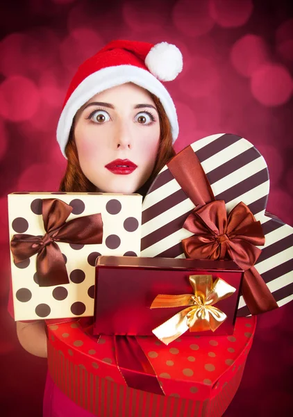 Redhead girl with gifts on red background — Stock Photo, Image